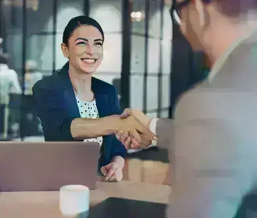 Woman on laptop shaking hands