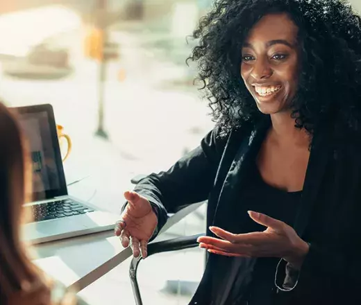 woman smiling and talking with coworker