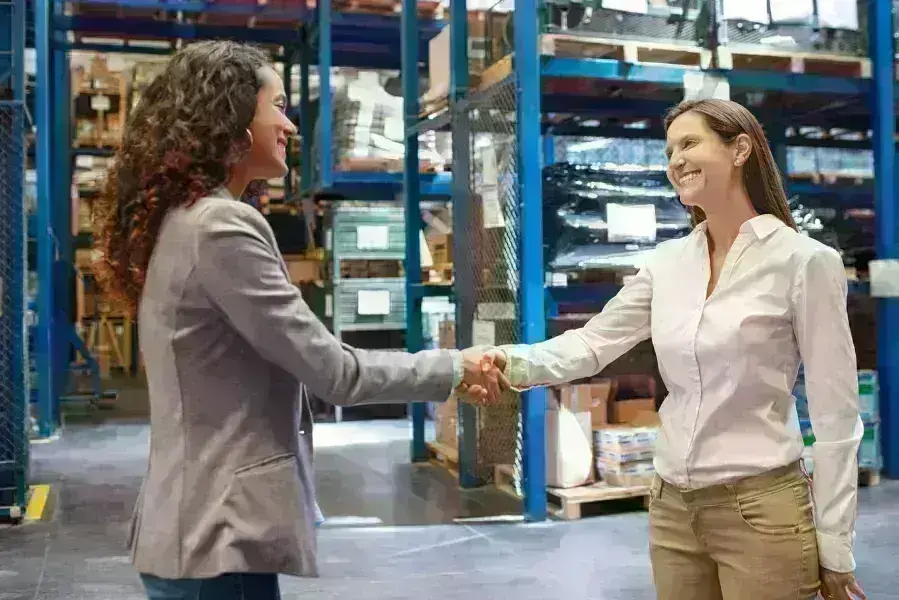 Ladies in warehouse shaking hands
