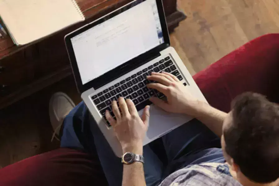 Someone on their laptop working and typing