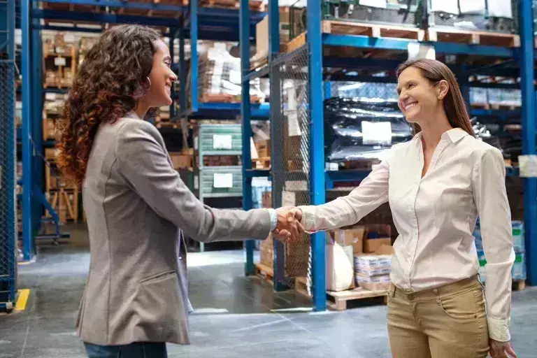 Ladies in warehouse shaking hands