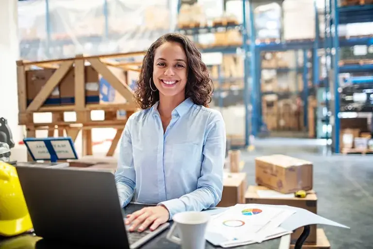 woman working on a laptop in a warehouse