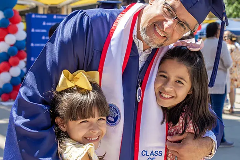 graduate student hugging children